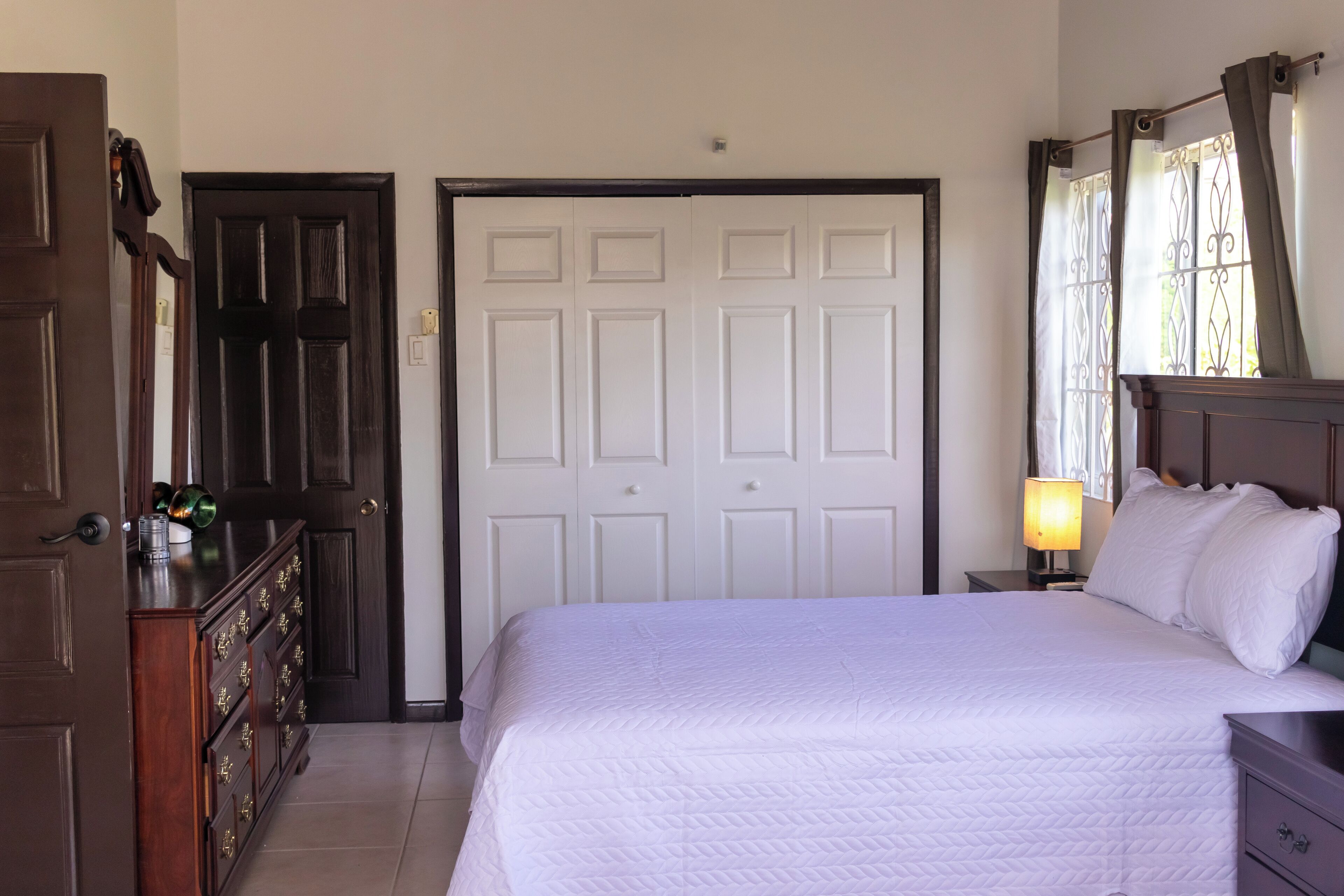 Un dormitorio con cama, cómoda y armario.