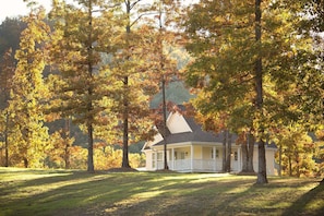A house surrounded by trees with autumn foliage. - Stonehill Cottages (Mena)