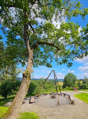 A park with a swing set, picnic tables, and a clear view of the surrounding landscape. - Vacation apartment with a view of the countryside - ideal for families and friends up to 6 pers. (Rothenberg)