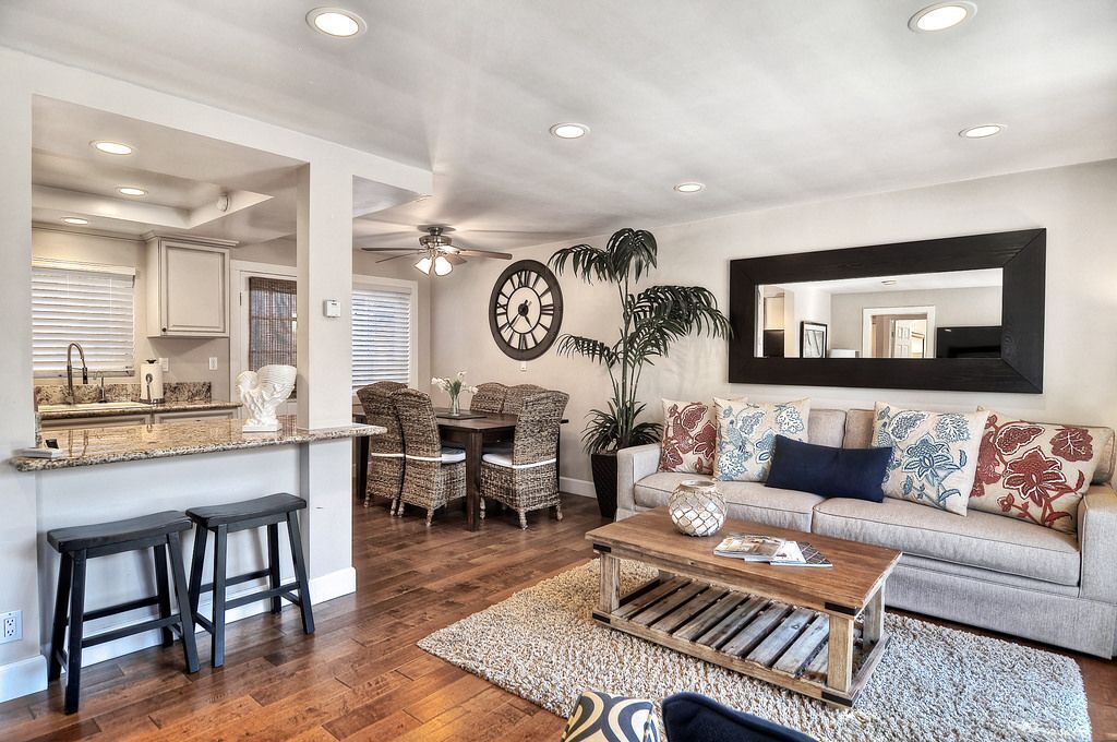 A modern living room with a sofa, coffee table, and dining area.