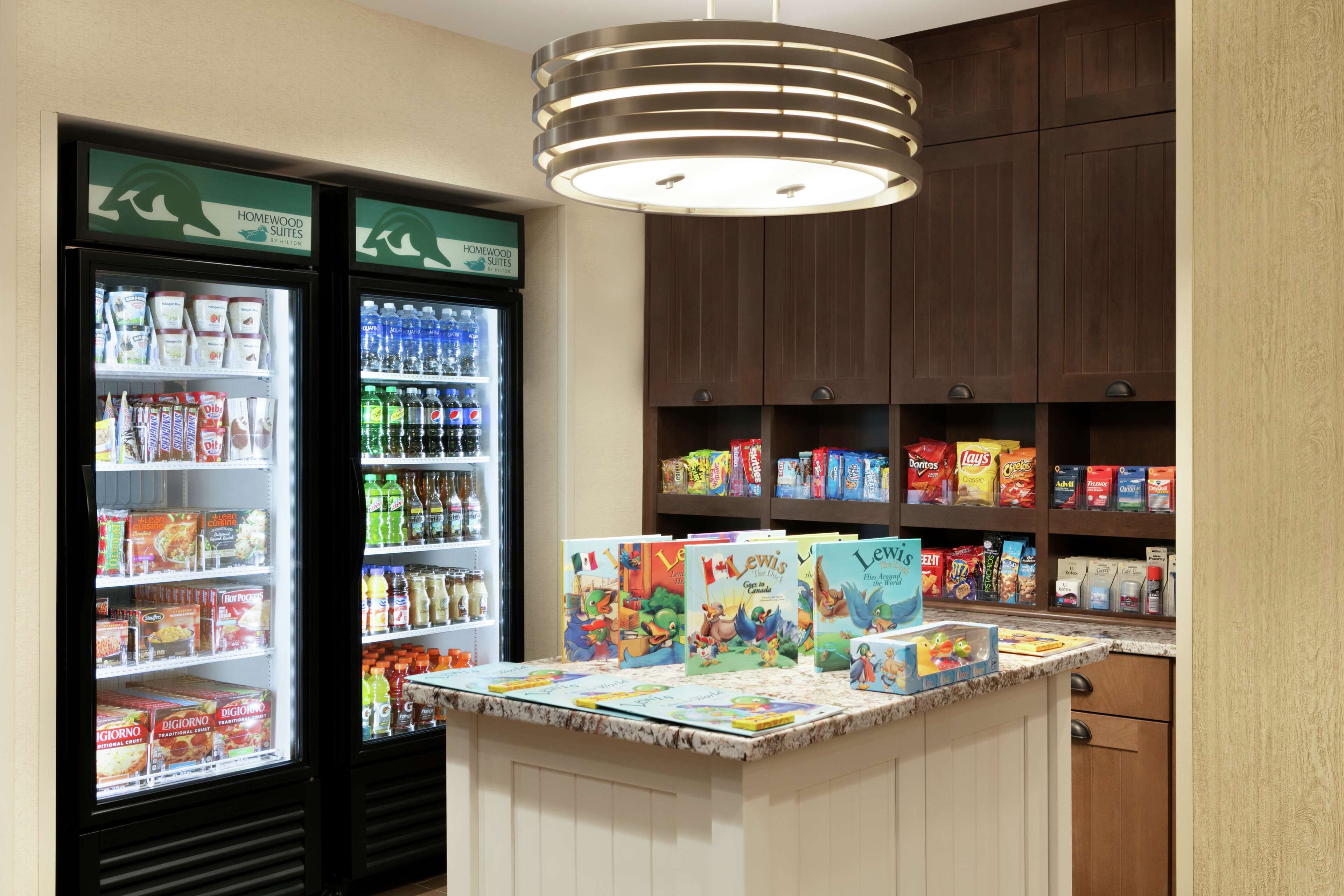 A kitchenette area with a refrigerator stocked with beverages and snacks, a microwave, and a coffee maker.