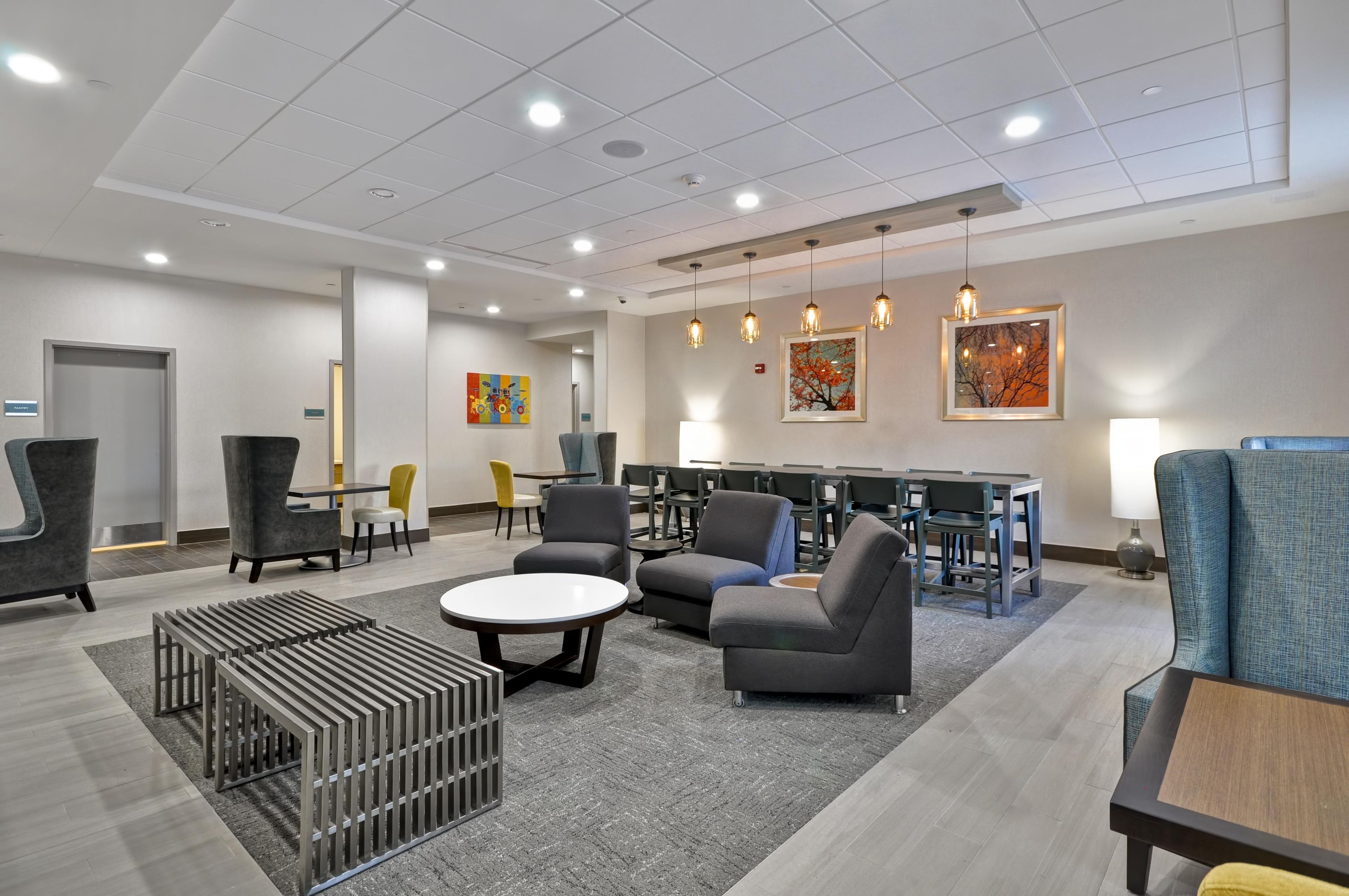 A modern lounge area with seating, tables, and artwork on the walls.