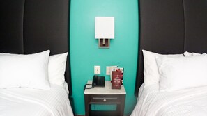 A hotel room with two beds, a nightstand, a phone, and a book. - Hotel Santa Fe (Tlatlauquitepec)