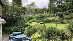 A garden with a picnic table and a clothesline. - Spacious stylish house for group stays in  beautiful Buxton, pet friendly.   (Buxton)