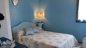 A bedroom with a bed, a nightstand with a lamp, a window, and a wall clock. - Light vacation apartment in Forio (Isola d 'Ischia - NA) (Casamicciola Terme)