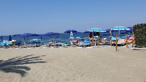 A beach with rows of blue and white umbrellas, sun loungers, and a lifeguard tower. - Light vacation apartment in Forio (Isola d 'Ischia - NA) (Casamicciola Terme)