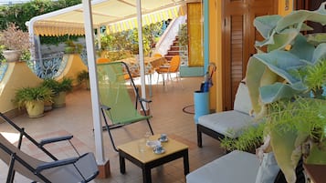A patio area with outdoor seating, a staircase, and potted plants.