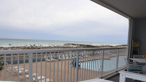 A balcony with a view of the beach, outdoor seating, and a pool area. - Islander Bch Resort 2004 by AJH Rentals FREE BEACH SERVICE+TICKETS! $349/Day (Fort Walton Beach)