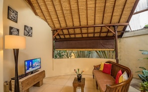 Relax in a serene space with a comfortable sofa, wooden table, and lush views.