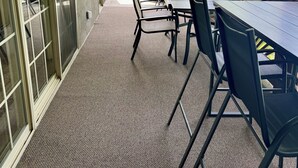 A covered patio with a table and chairs, a ceiling fan, and a view of greenery. - Enjoy sunsets, lake activies and Sports TV pkg at this Vickery Resort Condo (Hollister)