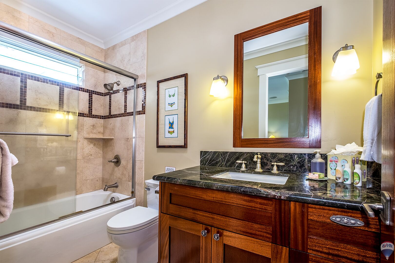 A bathroom with a bathtub, toilet, vanity with a sink, and a shower area.