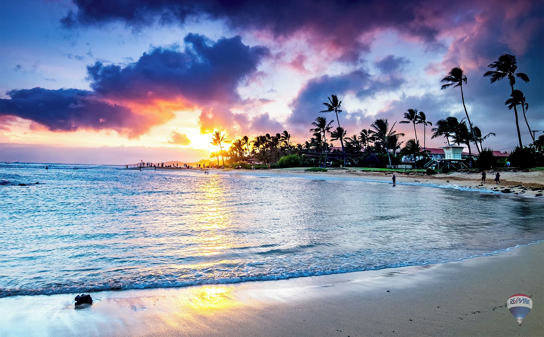 Une plage bordée de palmiers, avec un coucher de soleil.
