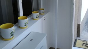 Una habitación con un armario blanco, una lámpara de pie y una ventana con vistas.