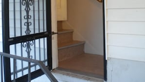 A staircase with a handrail and a door with decorative metal bars. - Zion and Bryce Canyon Getaway (Glendale)
