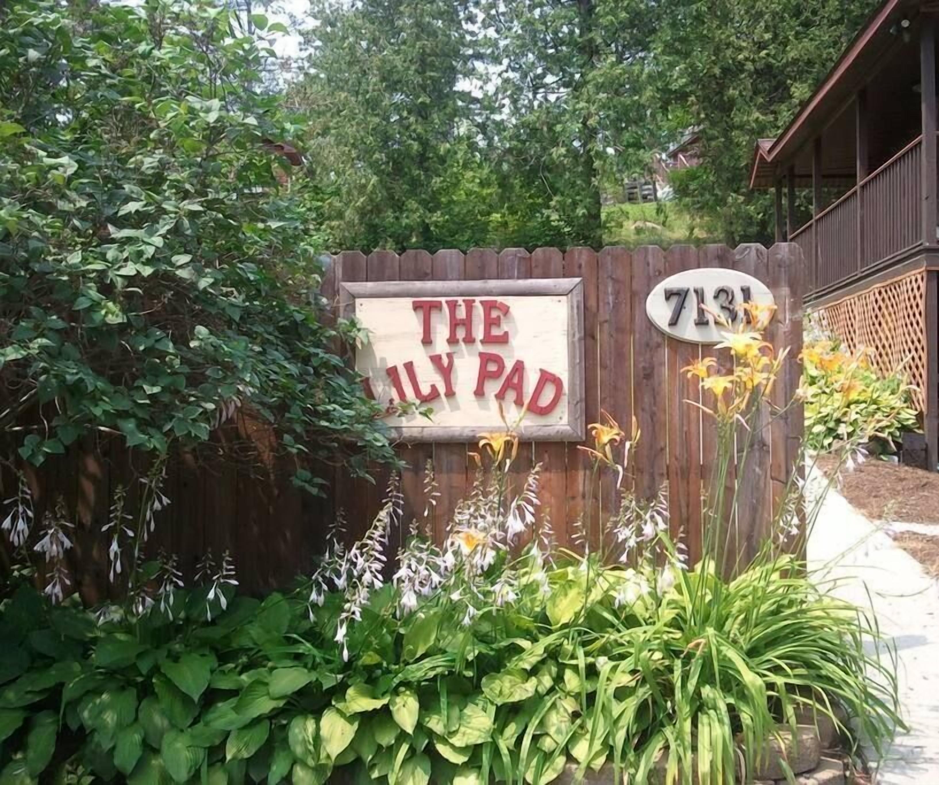 A wooden fence with a sign that reads 'THE FAMILY PAD' and a house number '7131'.