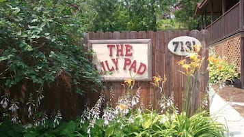 A wooden fence with a sign that reads 'THE FAMILY PAD' and a house number '7131'.