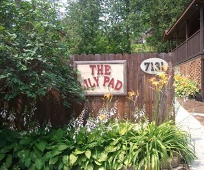 A wooden fence with a sign that reads 'THE FAMILY PAD' and a house number '7131'.