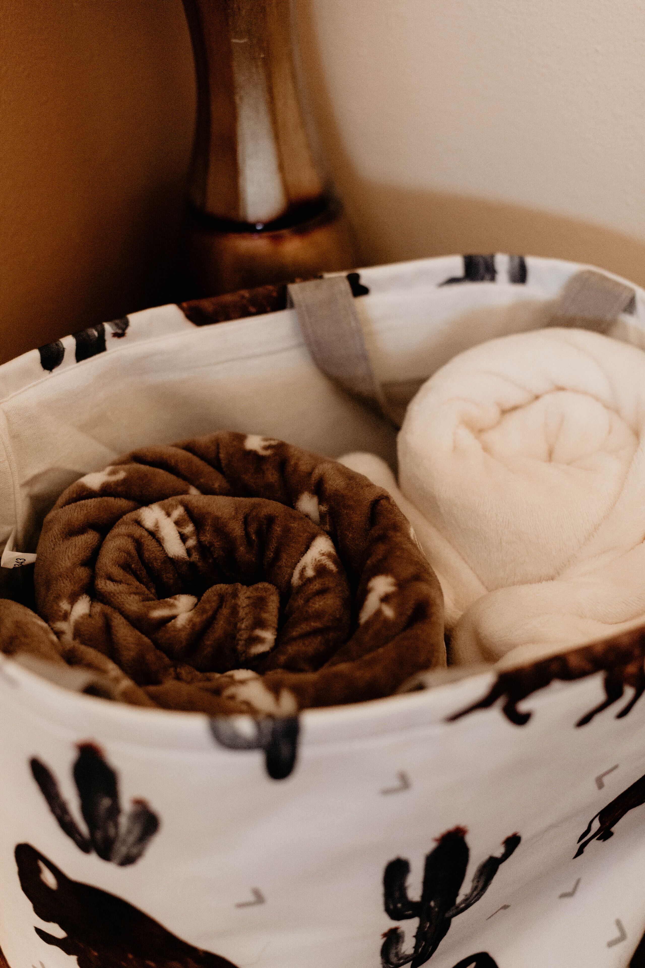 A bed with a white and brown patterned bedspread and a white pillow.