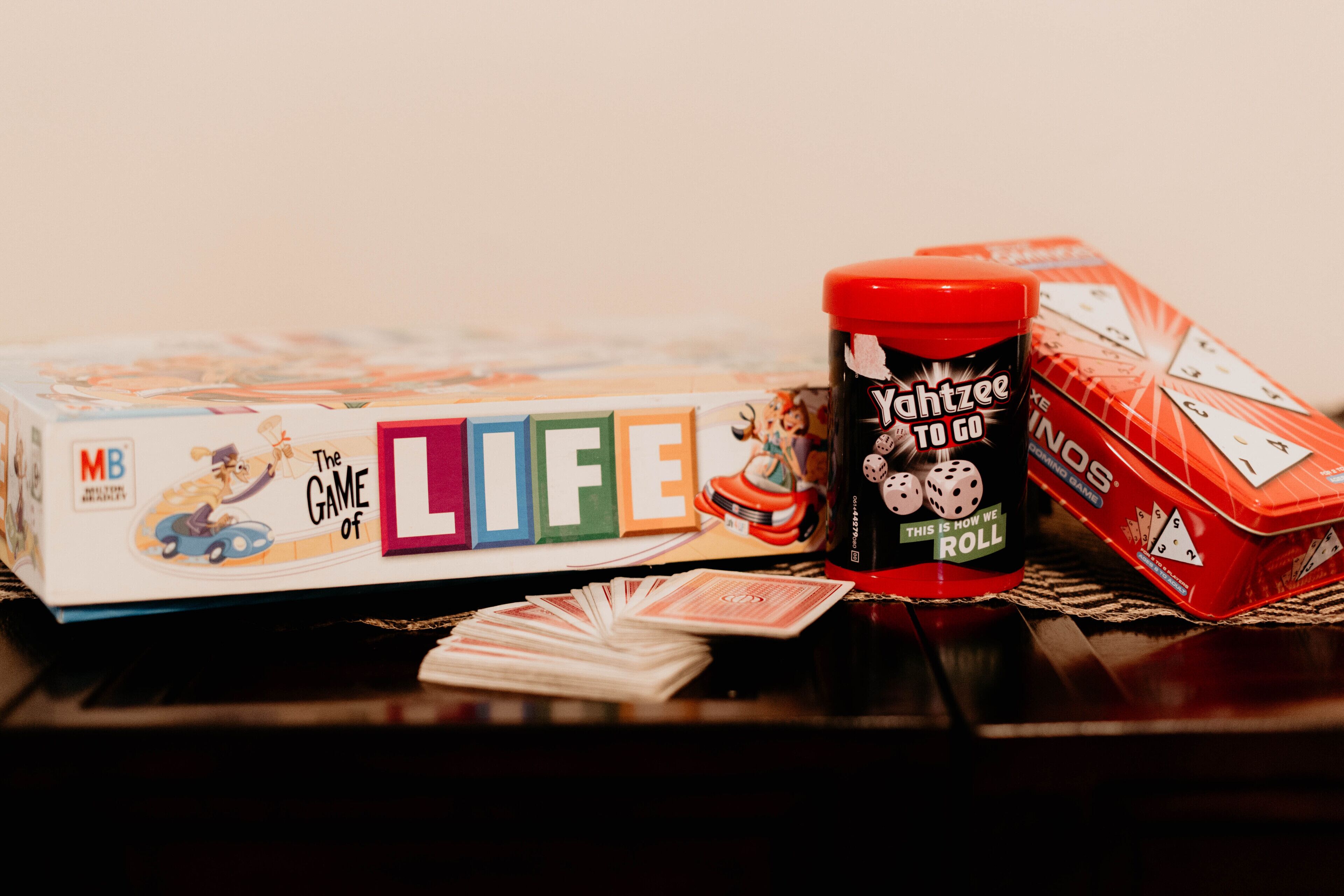 A board game titled 'The Game of Life' with dice and playing cards on a table.