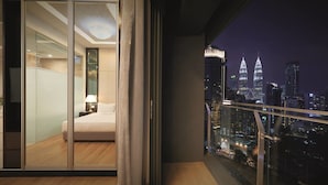 A modern hotel room with a large sliding glass door leading to a balcony with a city view. - Dorsett Residences Bukit Bintang at Dorsett Kuala Lumpur (Kuala Lumpur)