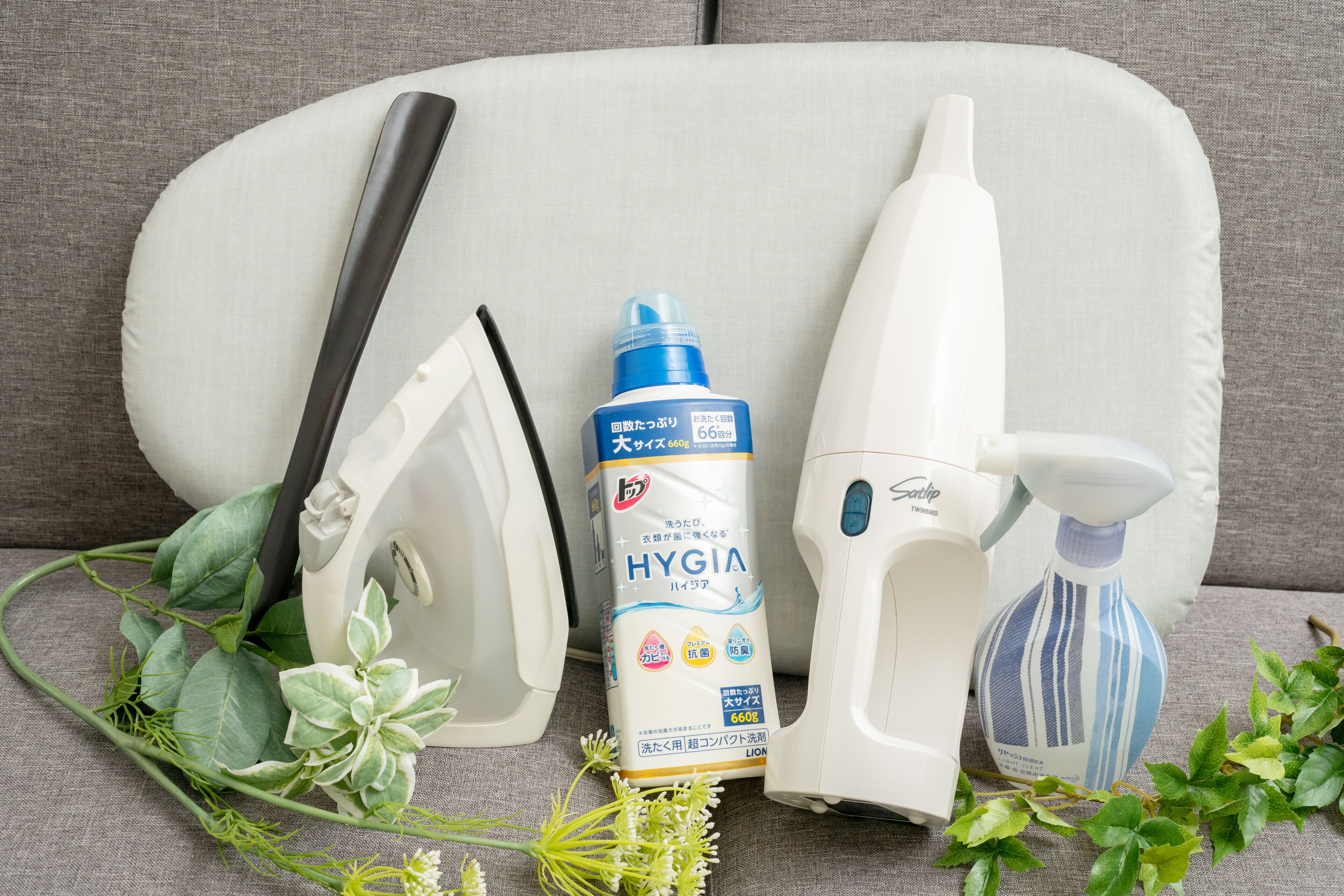 A white sofa with a spray bottle, a white bottle, and a white spray bottle on it.