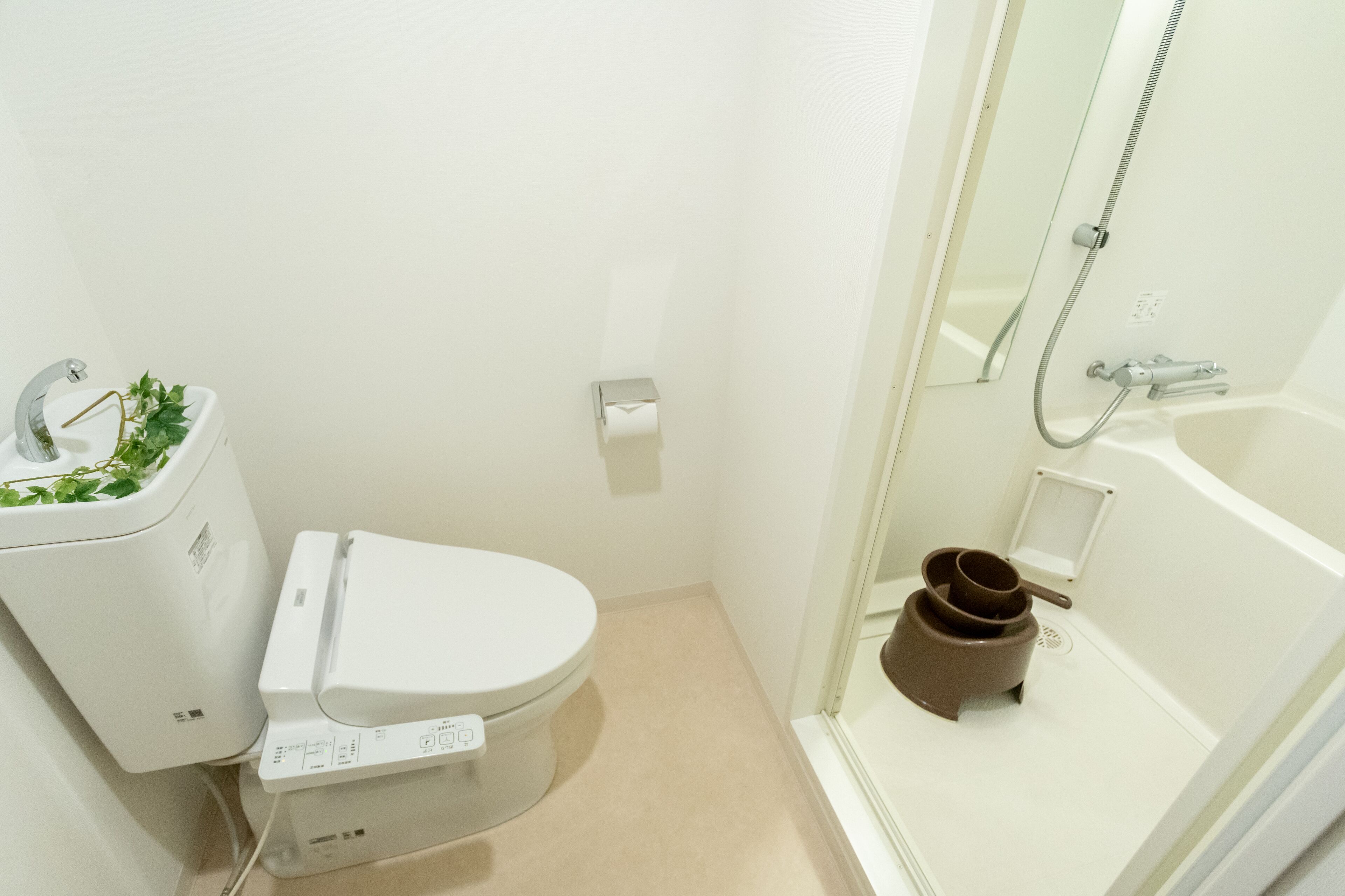 A modern bathroom with a toilet, bidet, and shower.