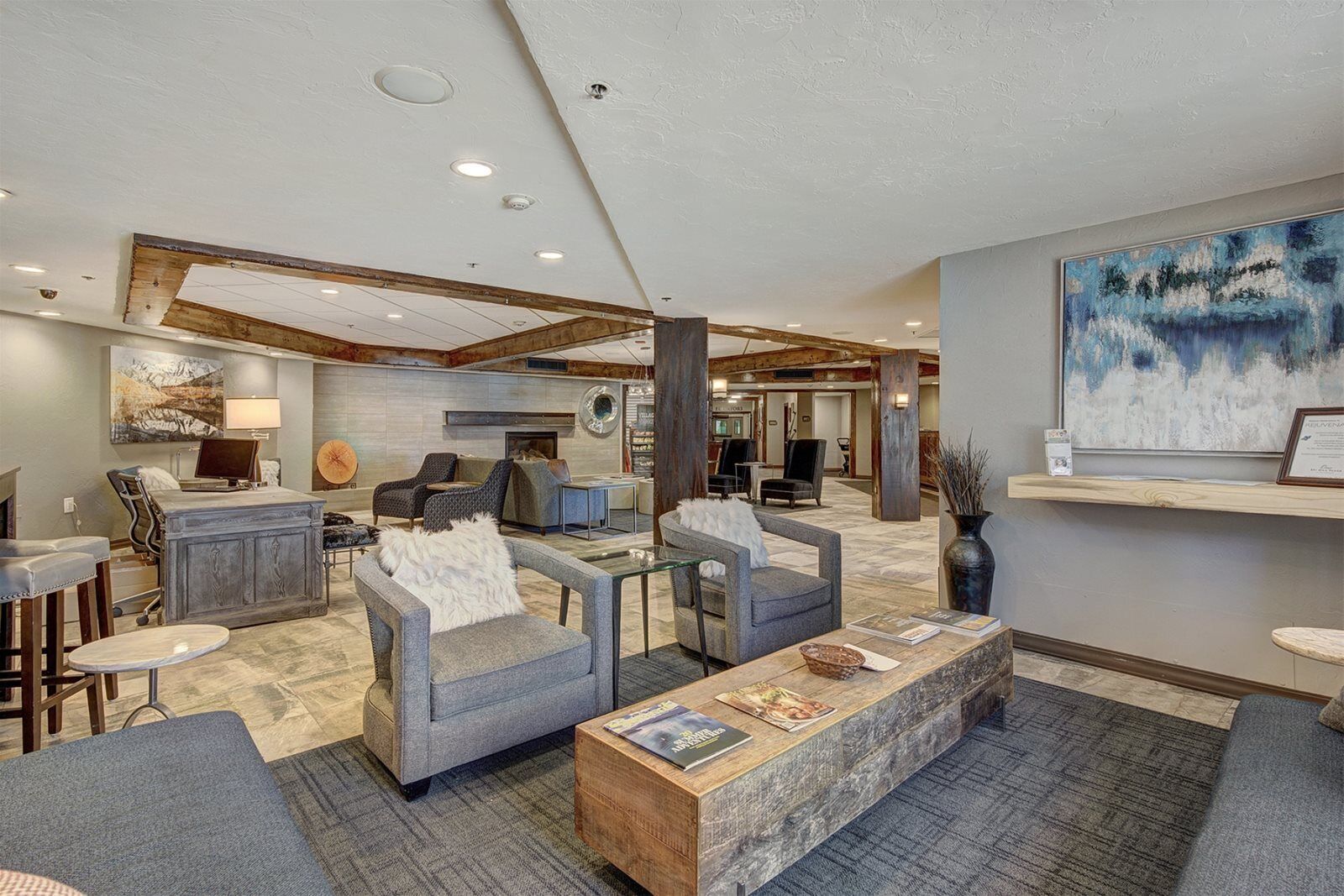 A spacious lobby with a reception desk, seating area, and a fireplace.
