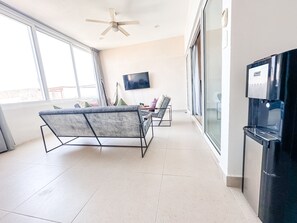 Relax in a spacious living area with a large window, ceiling fan, and flat-screen TV.