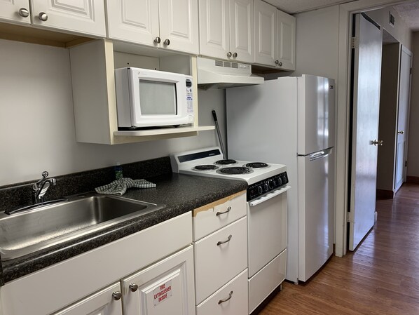 Stort kylskåp, mikrovågsugn, spishäll och kaffe- och tebryggare