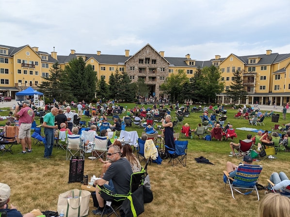 A large outdoor gathering in a courtyard with yellow buildings in the background.
