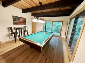 Enjoy a game of pool or dine with friends in this room featuring a pool table, dining table, and comfortable seating.