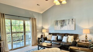 A living room with a leather sofa, a coffee table, and a large window with curtains. - 3 BR 2 Bath Lakefront Condo Vickery Resort with dock access. (Hollister)