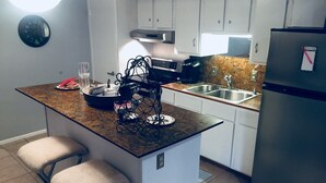 A compact kitchen with a central island, a refrigerator, and a sink. - Yacht Club, Golf course, lake view, ground floor condo (Montgomery)