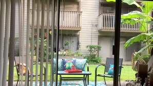 A patio area with a table and chairs, a patterned rug, and a view of a building with balconies. - Yacht Club, Golf course, lake view, ground floor condo (Montgomery)