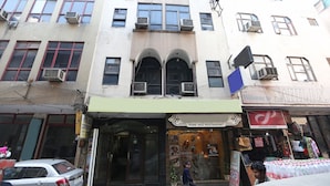 Un edificio de varios pisos con un restaurante llamado "Pure Veg Restaurant" y una tienda llamada "Sahil DX".