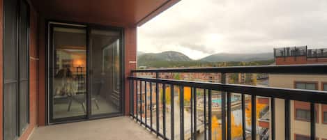 Un balcón con vistas a un paisaje urbano y montañas.