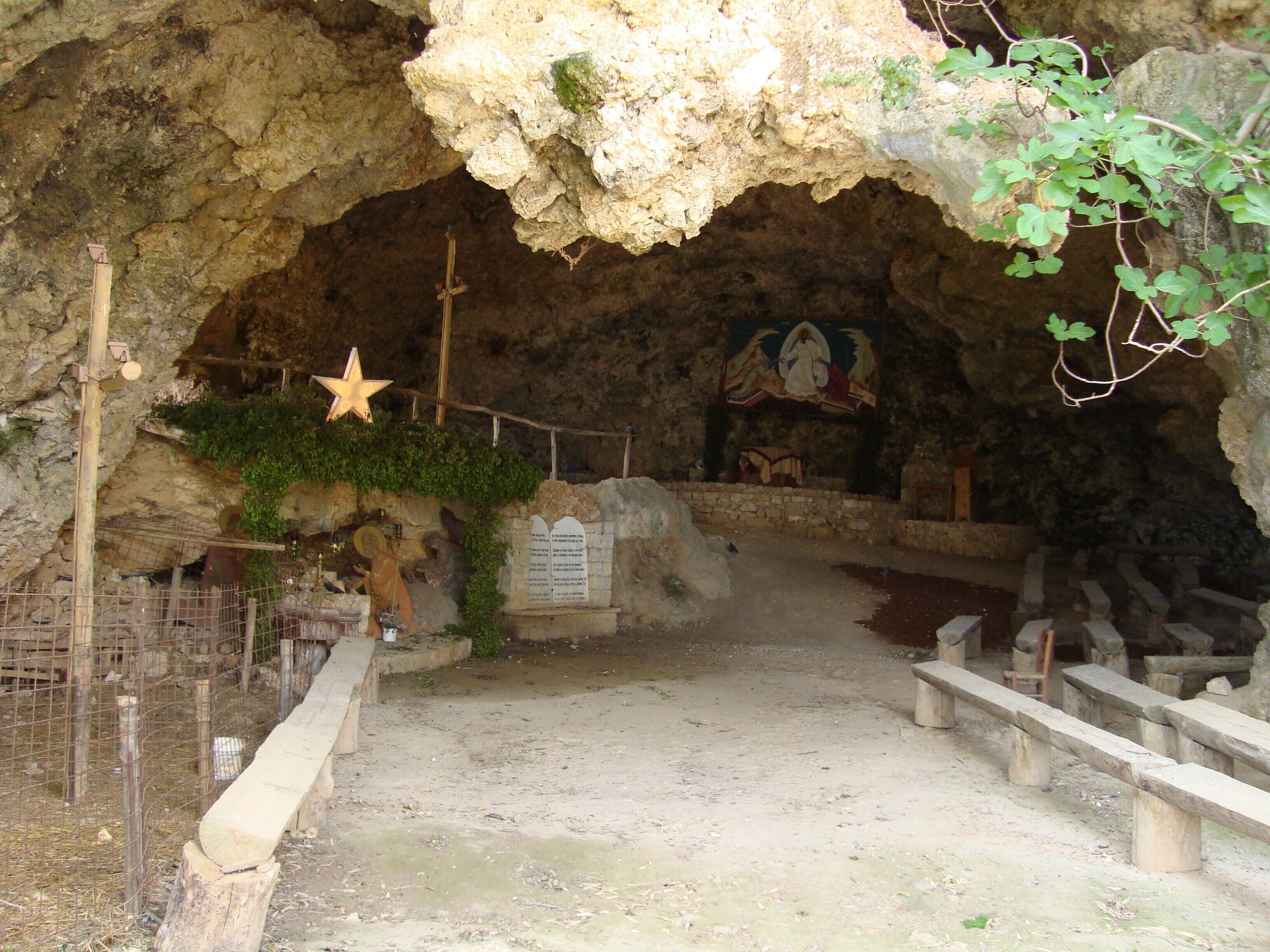 A cave-like interior with a star decoration, a mural, and stone benches.