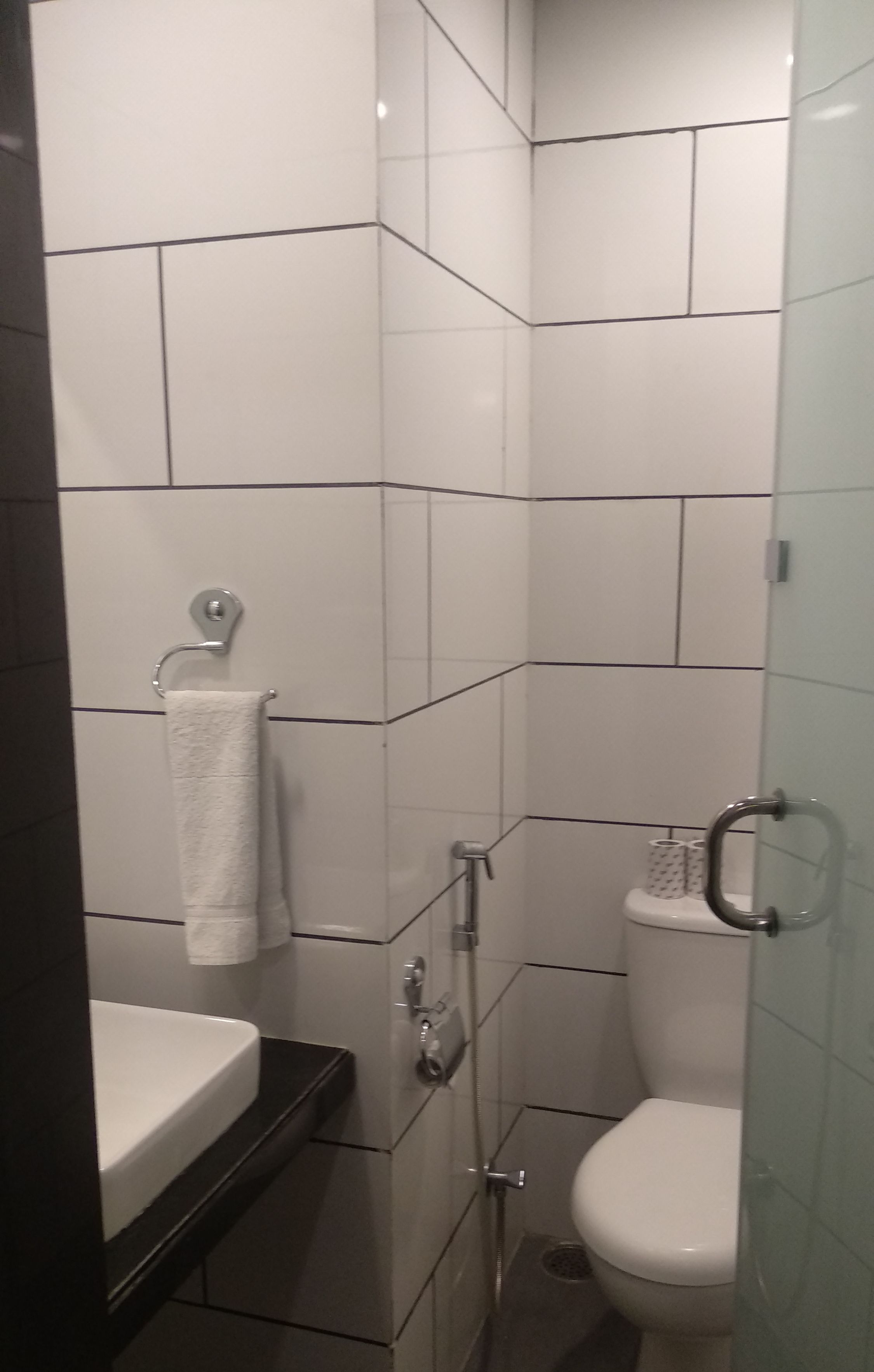 Un baño con lavamanos, inodoro y ducha blancos.