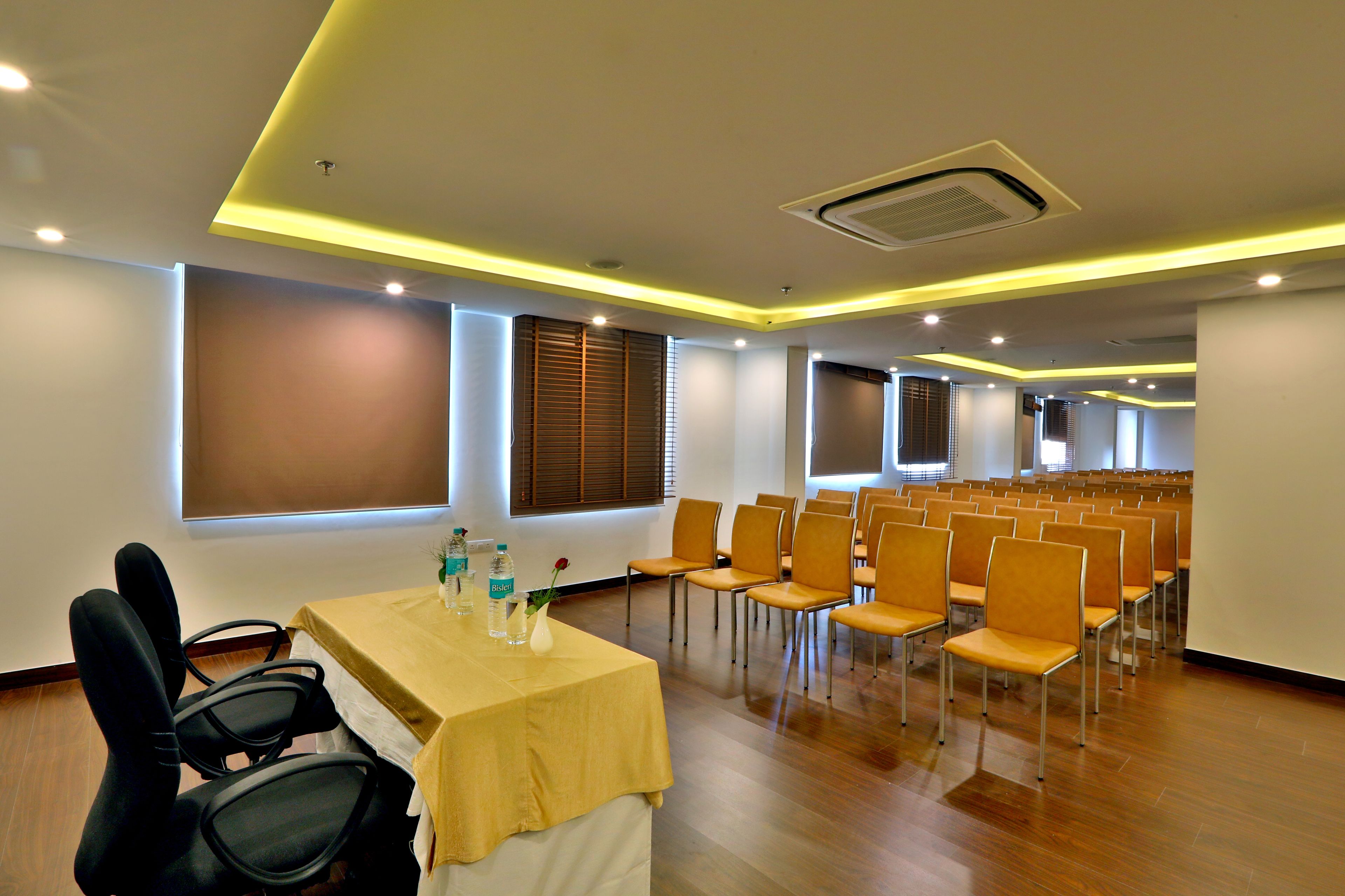 A conference room with a long table, multiple chairs, and a projector screen.
