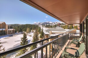 A balcony with a view of a ski resort, including buildings and snow-covered mountains. - Ten Mile Condo (Breckenridge)