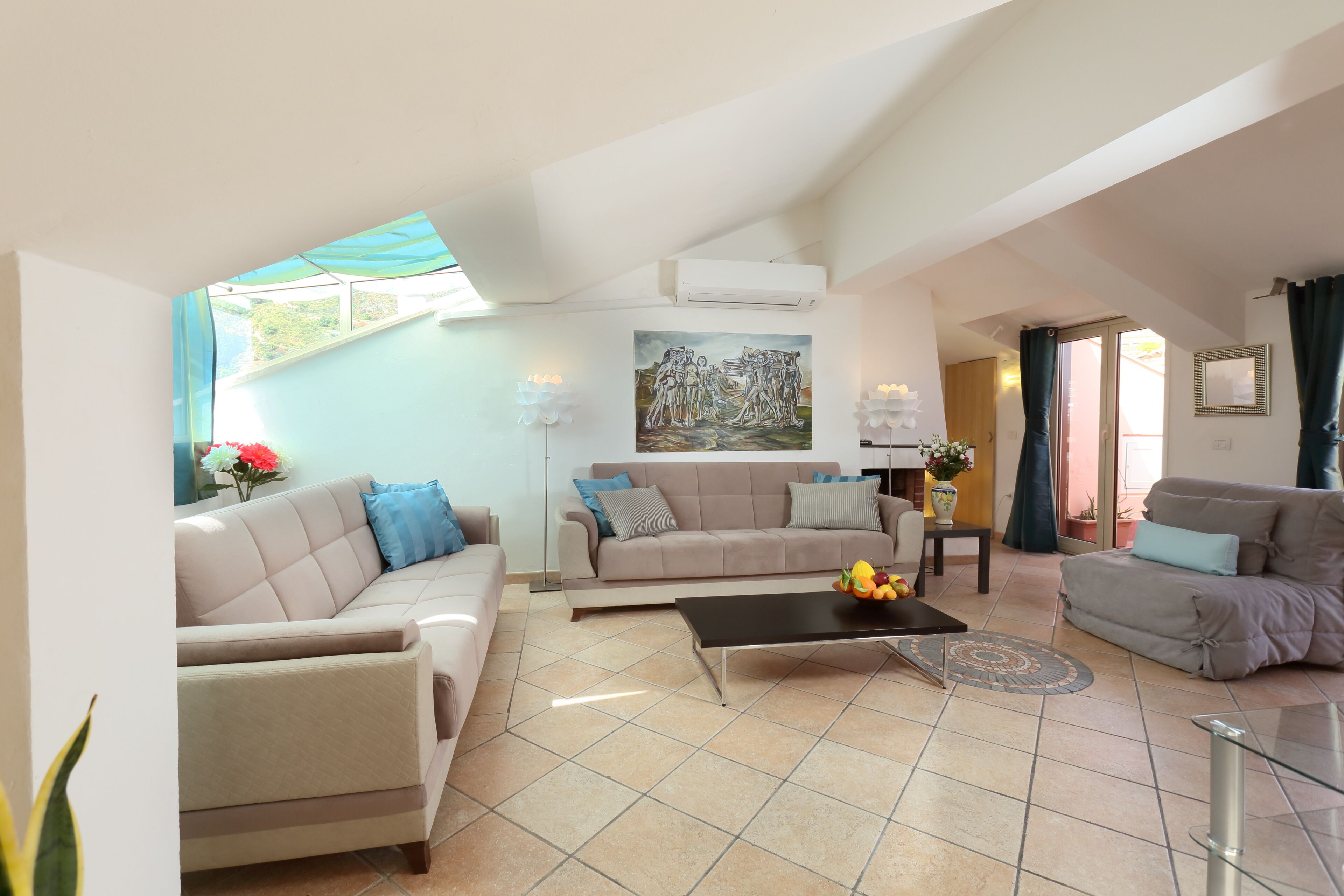 A spacious living area with a beige sofa set, a coffee table, and a painting on the wall.