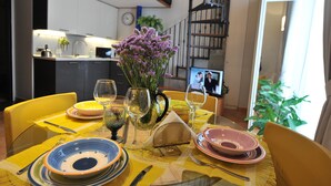 Una mesa de comedor dispuesta con platos, vasos y un florero.