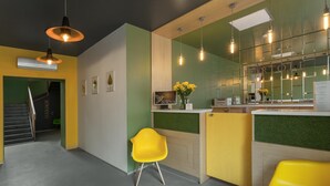 Eine moderne Küche mit einer grünen Arbeitsplatte, gelben Stühlen und Pendelleuchten.
