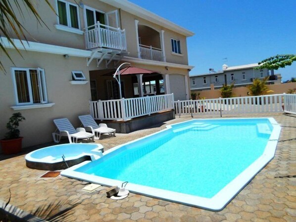 Utomhuspool, parasoller och solstolar