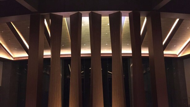 Een modern interieur met hoge, slanke zuilen en ingebouwde verlichting.
