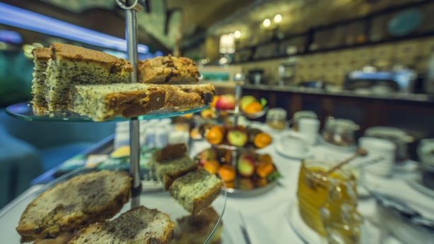 A buffet with various food items including cakes, pastries, and fruits.