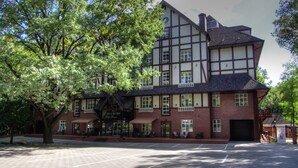 A traditional half-timbered building with a large tree in front.