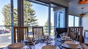 Mesa de jantar posta para quatro, com vista para árvores e uma estrada.