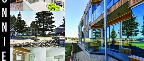 A modern building with a glass facade, a wooden deck, and a view of the surrounding landscape.