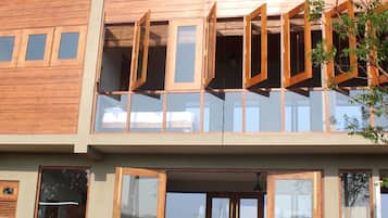 Una casa moderna de dos pisos con grandes ventanales y fachada de madera.